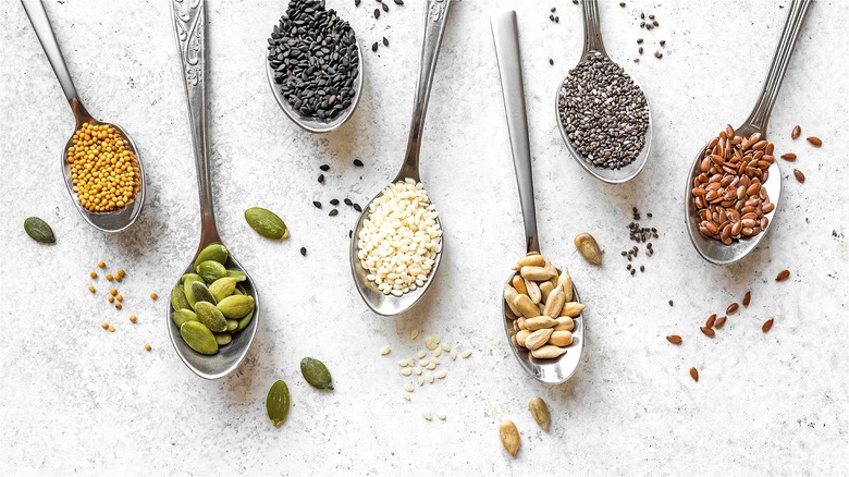 Assorted seeds on metal spoons 