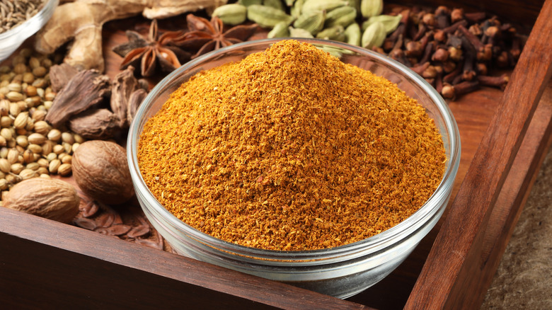 Curry powder in bowl with spices in back