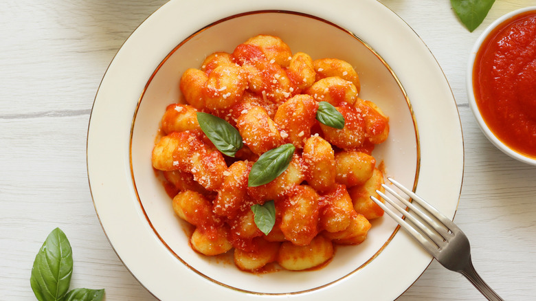 bowl of gnocchi with tomato sauce and basil