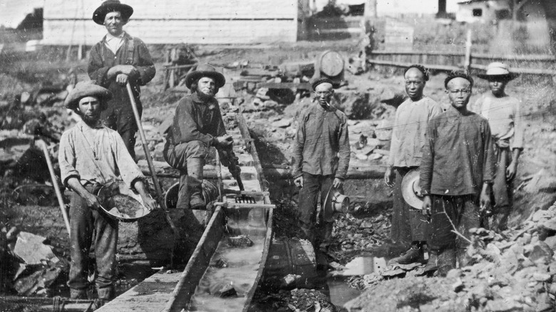 Black and white photo of several men mining for gold