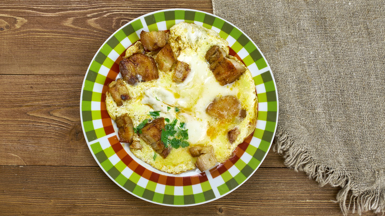 green checkered plate on wood and burlap, with eggs and oysters on top