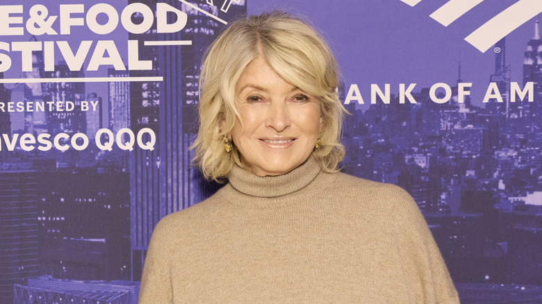 Close up of Martha Stewart smiling in front of a purple background