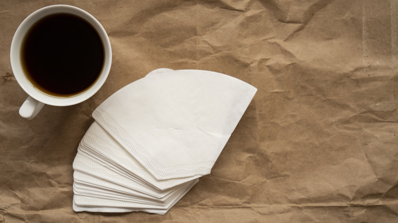 a cup of coffee and a stack of coffee filters