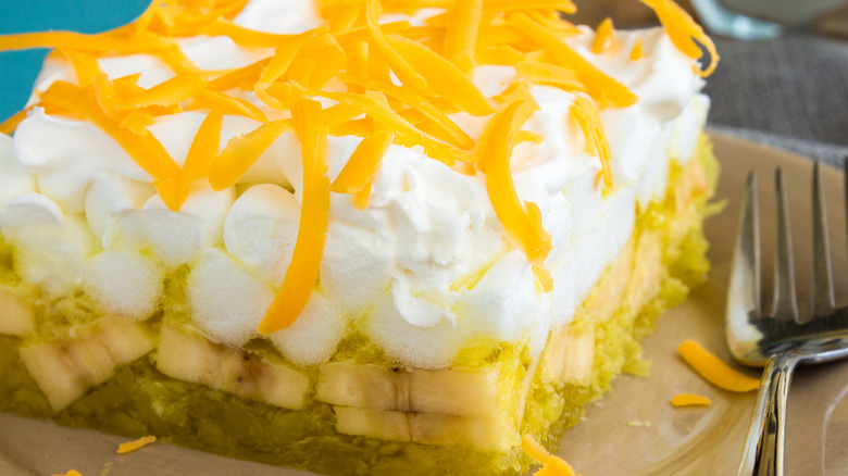 A close-up shot of a slice of yellow Jell-O salad on a plate.