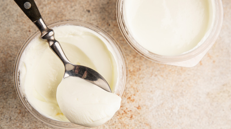Two cups of skyr or yogurt, one with a spoon in it