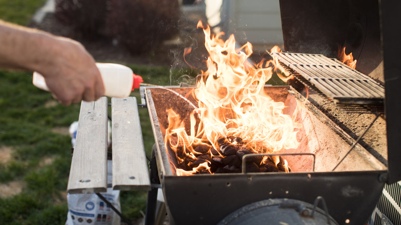 spraying grill with lighter fluid