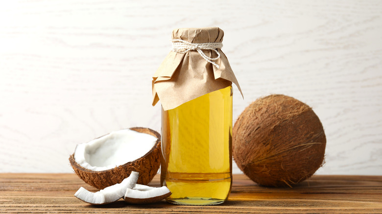 Bottle of olive oil with coconuts on the counter