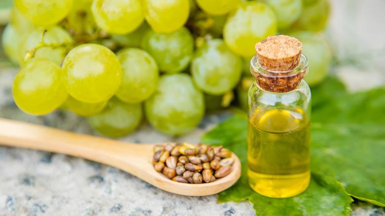 Bottle of grapeseed oil with grapes in the background