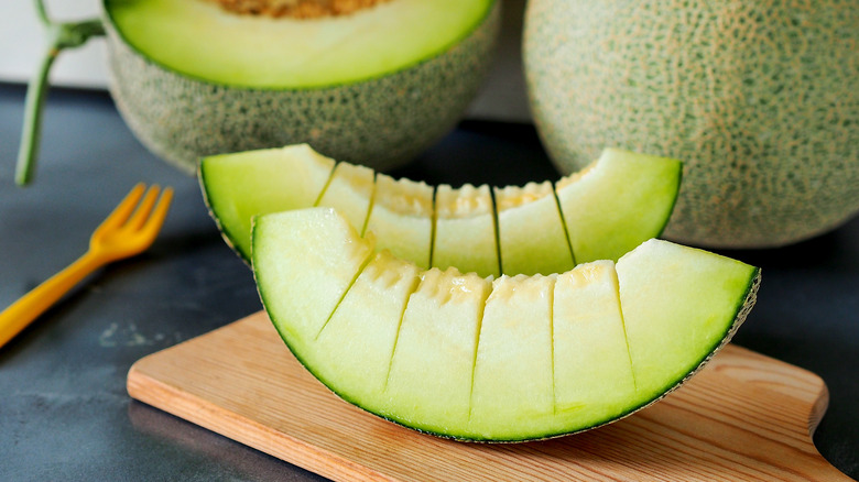 Honeydew melon slices on cutting board