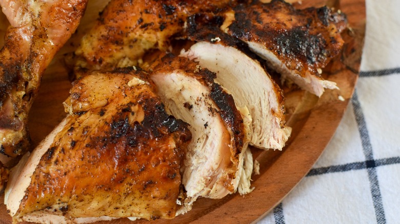 grilled beer can chicken on wood tray 
