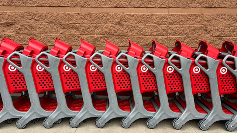 Red Target shopping carts in a line against a brick wall
