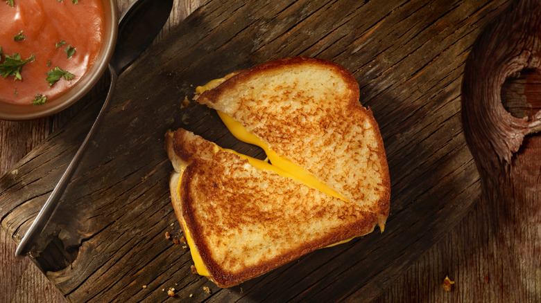 grilled cheese sandwich cut in half on wooden board