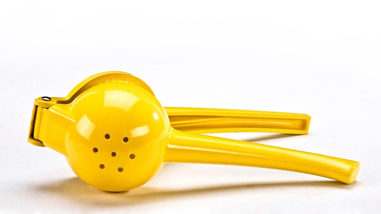 lemon press resting on white table