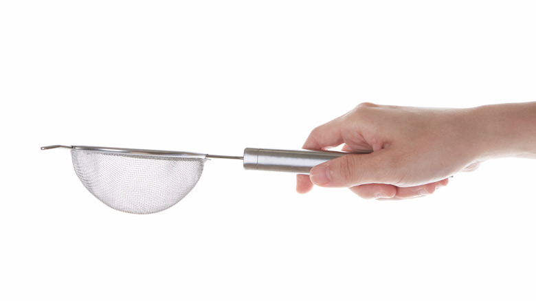 Person holding small sieve