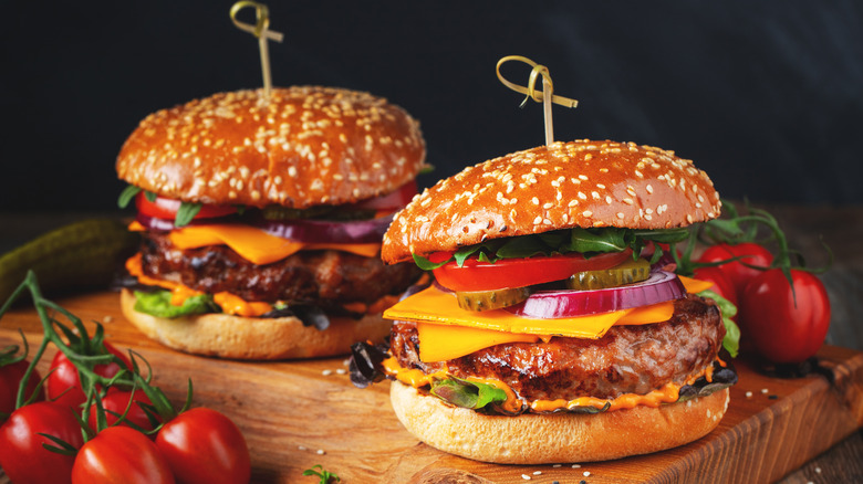 two homemade cheeseburgers on wooden board