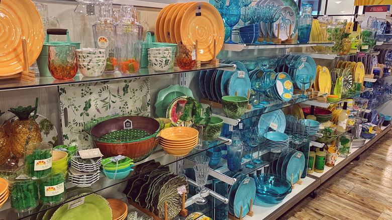 New York HomeGoods kitchenware aisle with colorful plates, cups, and other tableware items