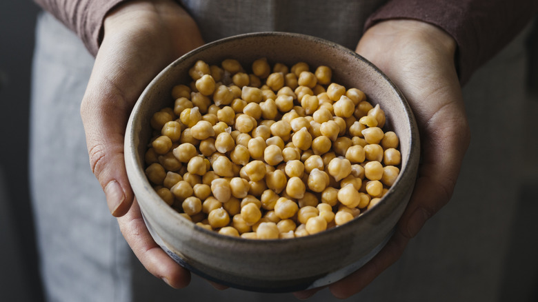 Person holding bowl of chickpeas