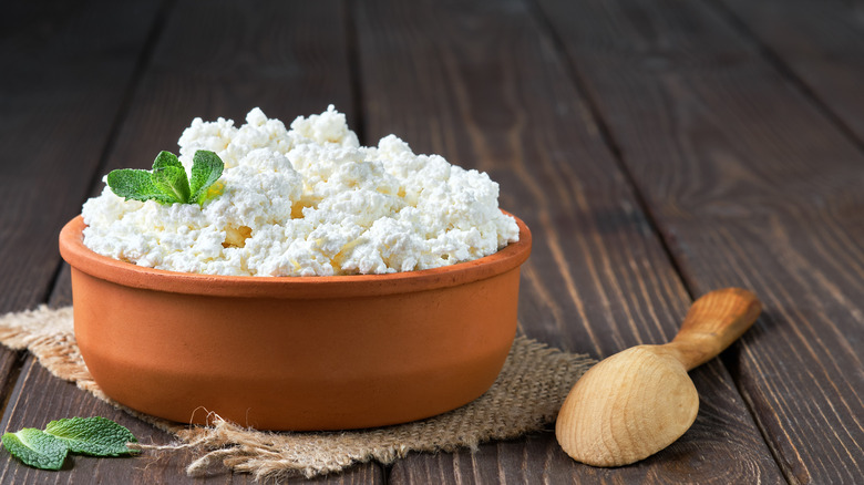 Bowl of cottage cheese with wooden spoon
