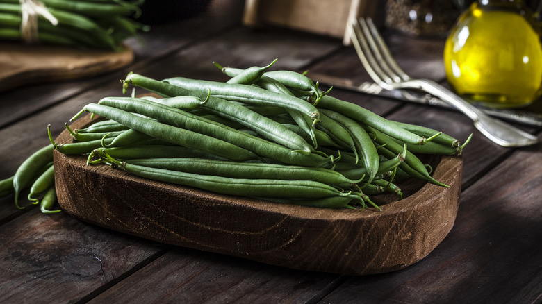 Green beans on wooden plate