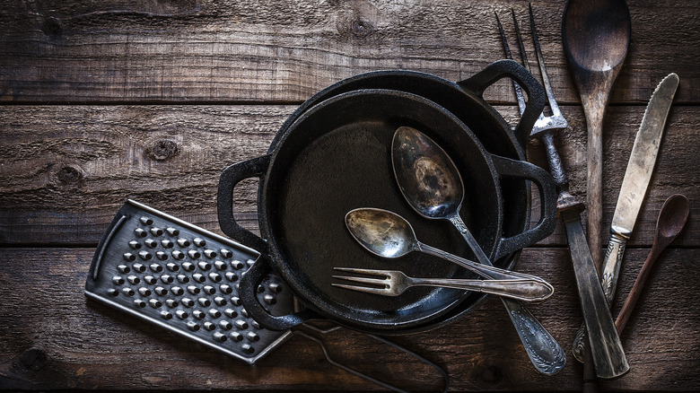 cast iron cookware with assorted cutlery