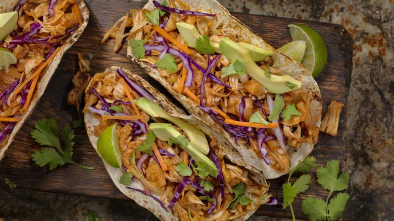 Jackfruit tacos on a wooden slab with lime