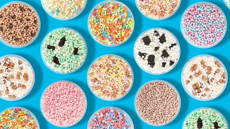 Three people hold cups of rainbow Dippin' Dots