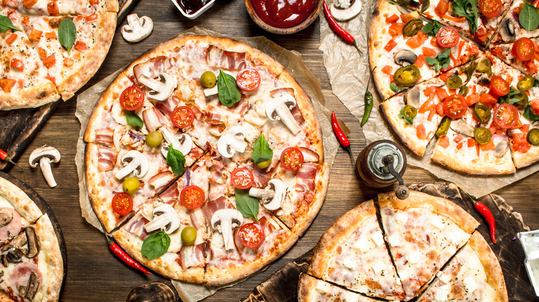 Various pizzas on wooden table