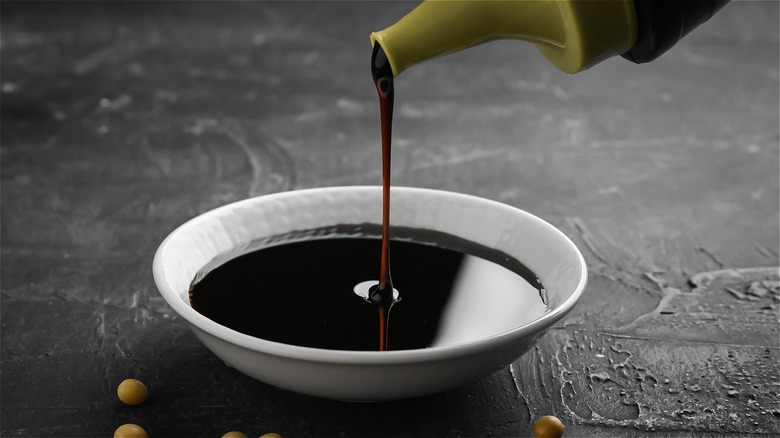 pouring soy sauce in a bowl