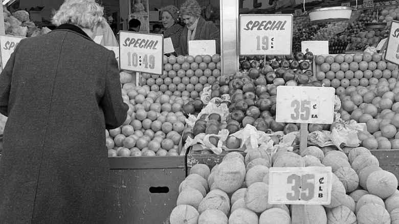 Woman looking at produce in 1970s grocery store