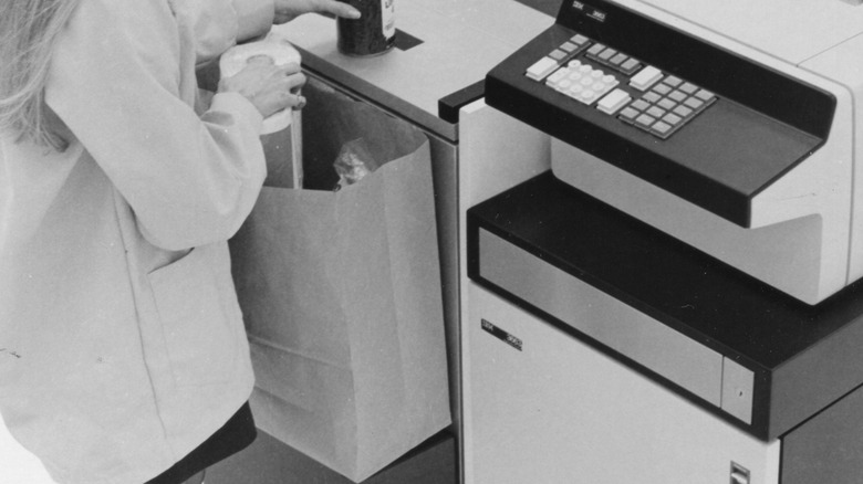 Grocery clerk bagging groceries into paper bag