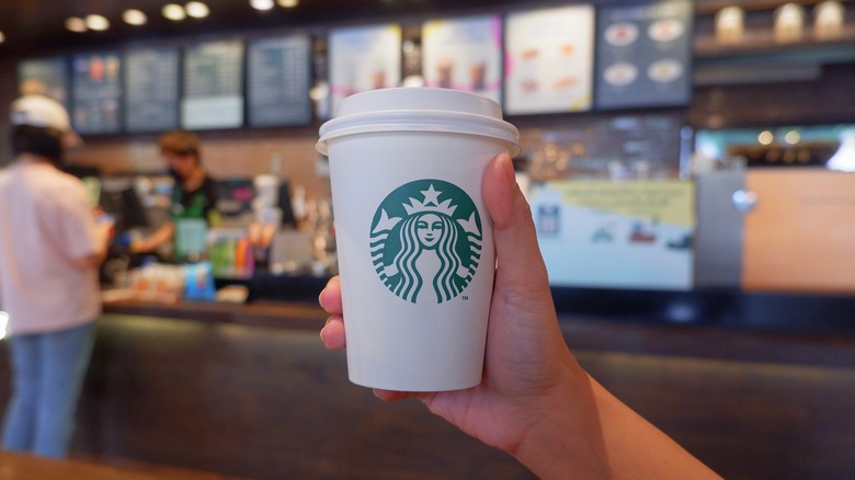 Hand holding a Starbucks cup