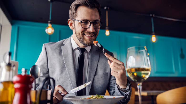white man with glasses and suit dining at a restaurant 