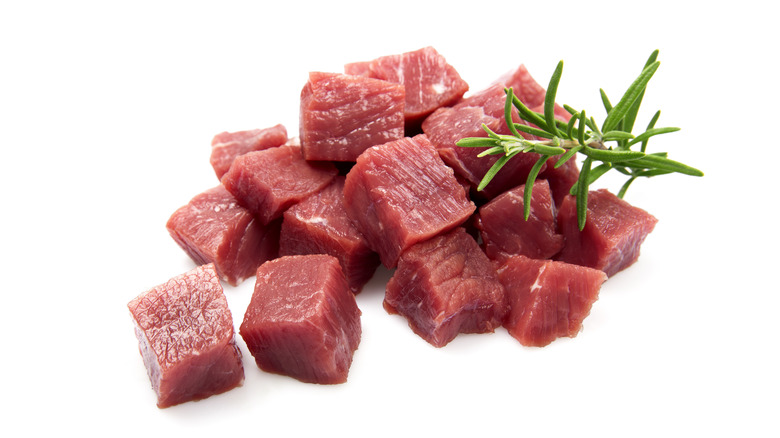 Raw steak cubes with garnish