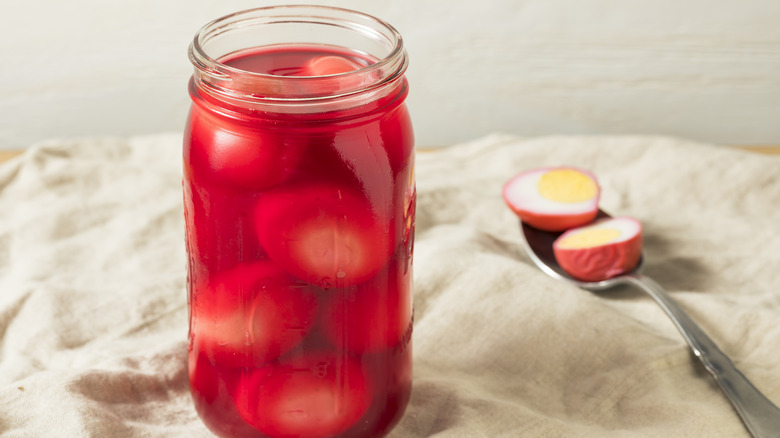 A jar of pickled eggs in red liquid