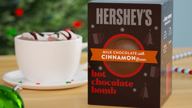 box of hershey's hot chocolate bomb next to mug