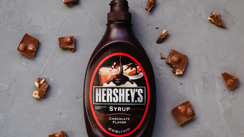 Hershey's syrup surrounded by pieces of chocolate hazelnut