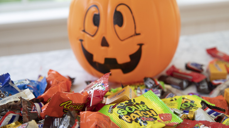 Plastic Jack o' Lantern next to a pile of Hershey's brand candies