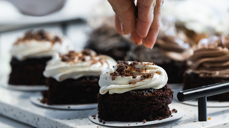 Pastry Chef putting finishing touches on a cupcake