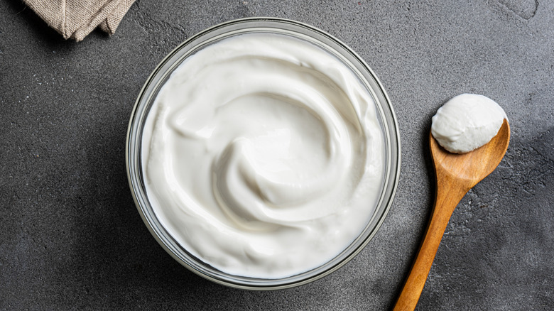 Greek yogurt in a bowl, with a spoon on the side