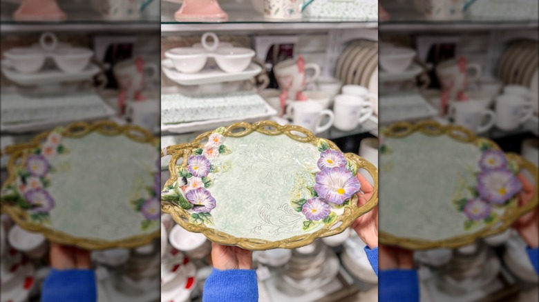 Hands holding flower-patterned serving dish in HomeGoods