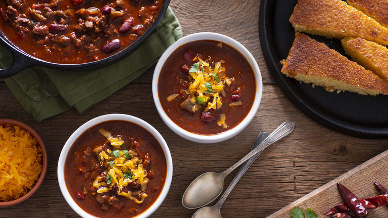 Bowls of chili with cheese and cornbread