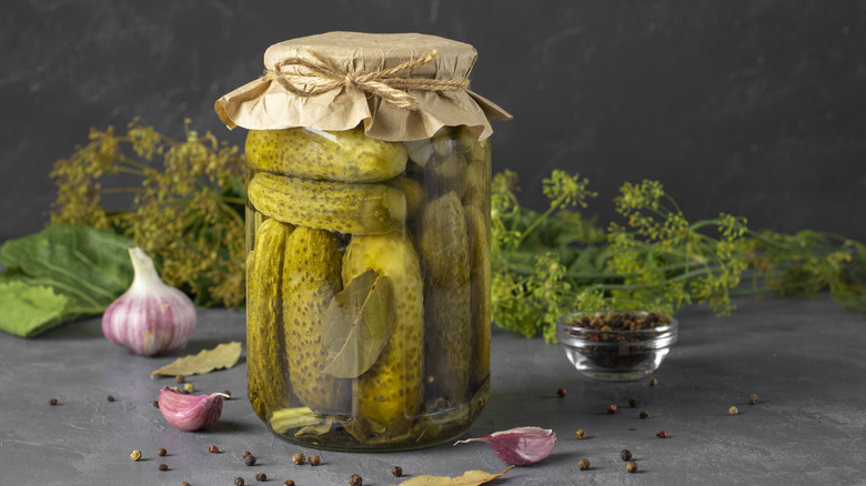 Jarred pickles with peppercorns, garlic, horseradish