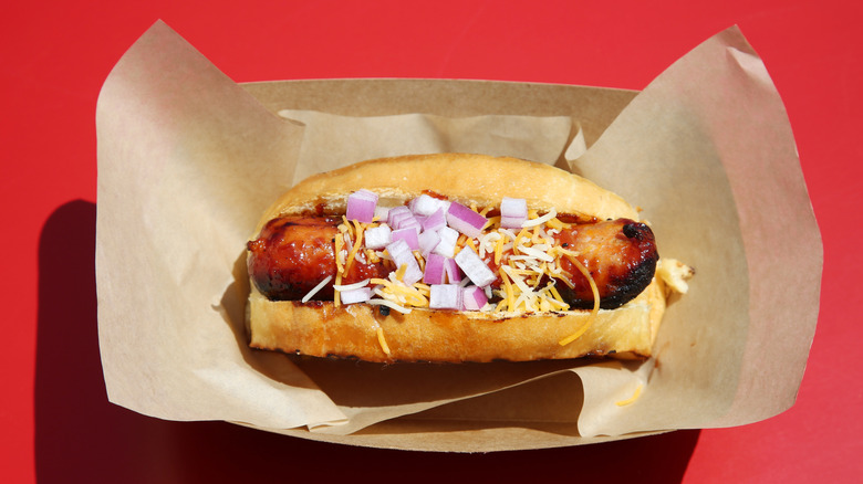 Char Grilled Louisiana Hot Link Sausage Topped with Cheddar Cheese, and Red Onions