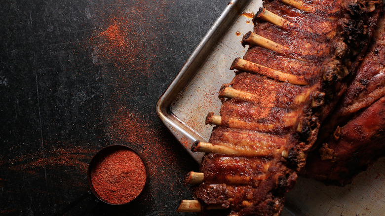 Rack of ribs on a sheet pan with dry rub spices
