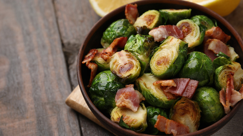 A bowl of browned Brussels sprouts with thick pieces of bacon