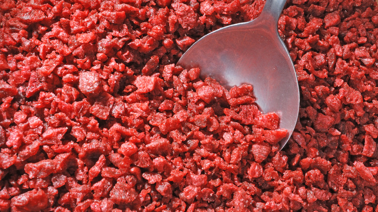 A spoon in bacon bits.