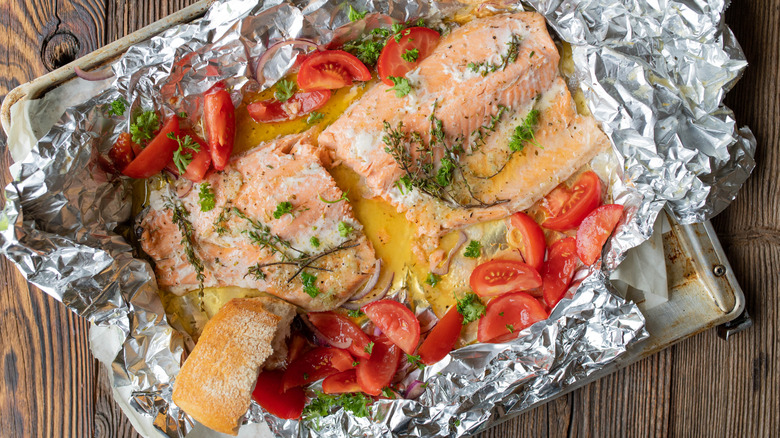 Salmon and tomatoes on a foil-covered sheet pan