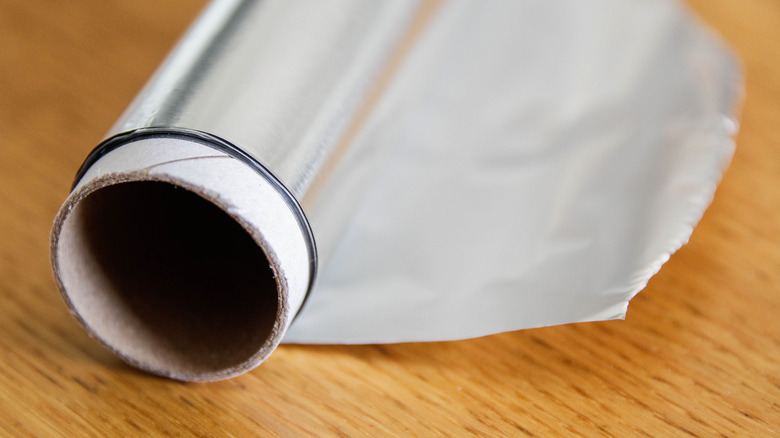 Roll of aluminum foil on wooden table