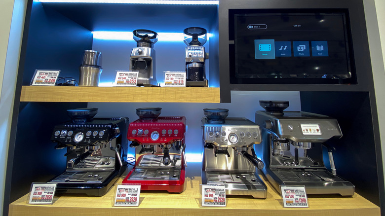 Breville espresso machines and grinders sit on store shelves.