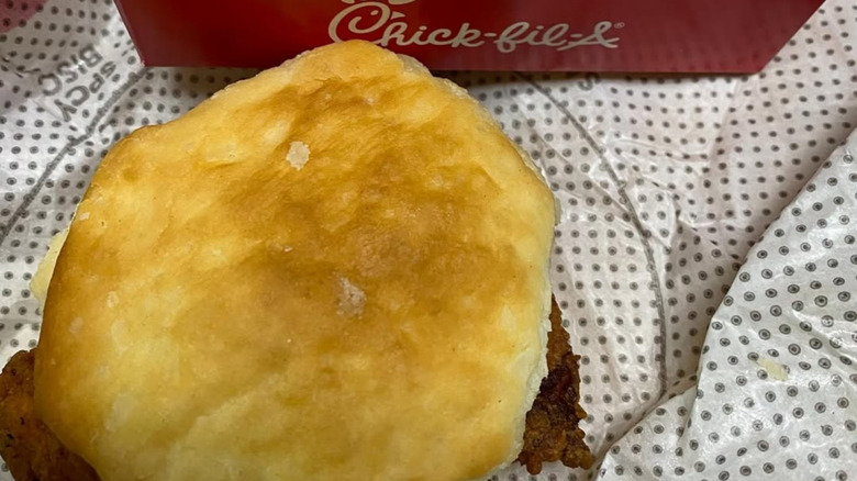 A Chick-fil-a station that is closed next to a giant version of the logo